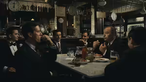 Robert De Niro and other men seated at a table in a restaurant