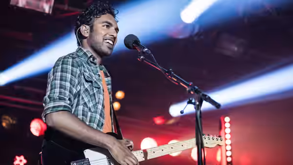 Jack Malik (Himesh Patel) singing and playing electric guitar on a concert stage