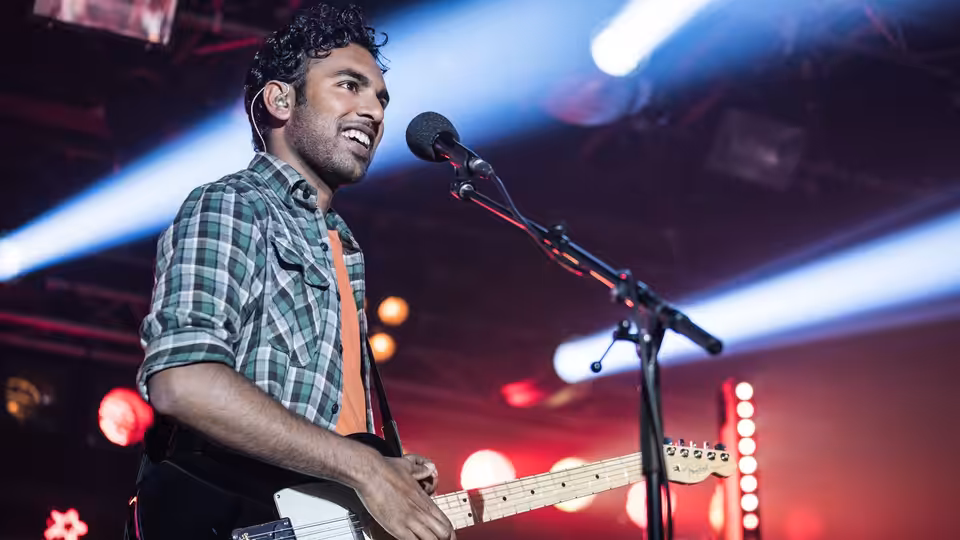 Jack Malik (Himesh Patel) singing and playing electric guitar on a concert stage