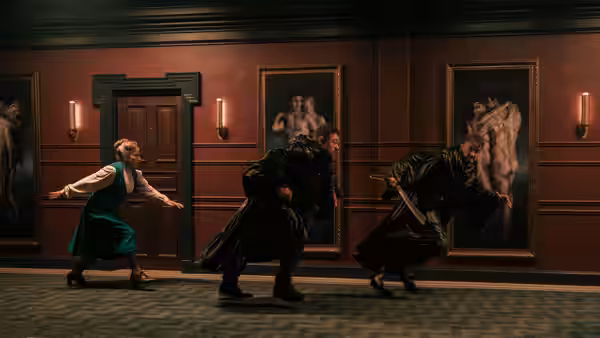 Asia Reaves (Zazie Beetz) fights black-robed figures in a paneled hallway
