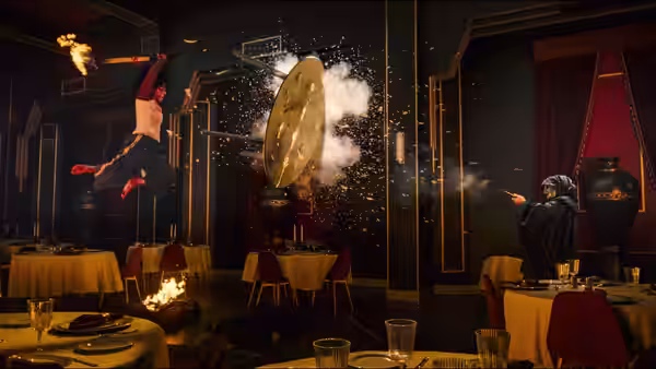 A person flies across a dining room as a black-robed figure aims a weapon