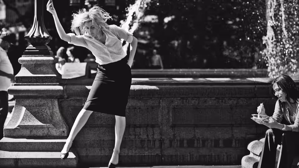 Frances (Greta Gerwig) dancing with arm raised beside a stone fountain