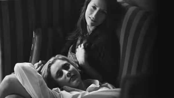 Frances (Greta Gerwig) resting on a striped couch with Sophie (Mickey Sumner)