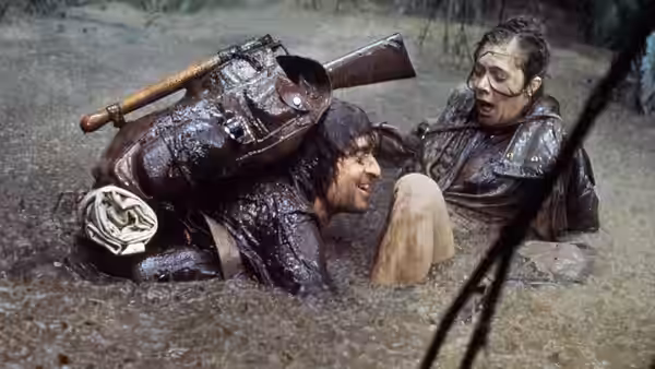 Jack Colton and Joan Wilder struggle through thick mud with their packs