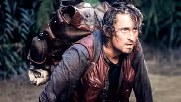 Jack Colton (Michael Douglas) carries a large pack through the jungle