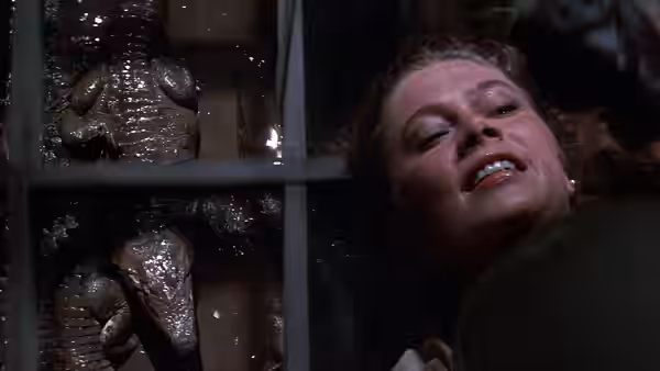 Joan Wilder (Kathleen Turner) recoils beside crocodiles behind bars