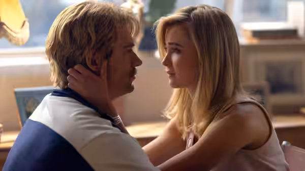 A man and woman hold each other close in a warmly lit room