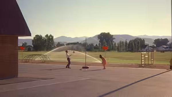 A boy and a girl playing tetherball on a school playground
