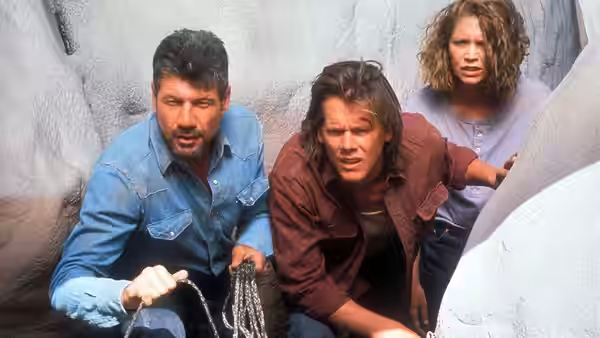 Earl Bassett (Fred Ward) and Valentine McKee (Kevin Bacon) holding chains with Rhonda LeBeck