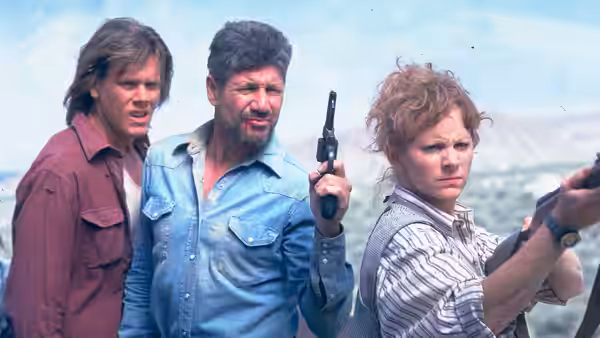 Valentine McKee (Kevin Bacon) and Earl Bassett (Fred Ward) with Rhonda LeBeck (Finn Carter) holding guns