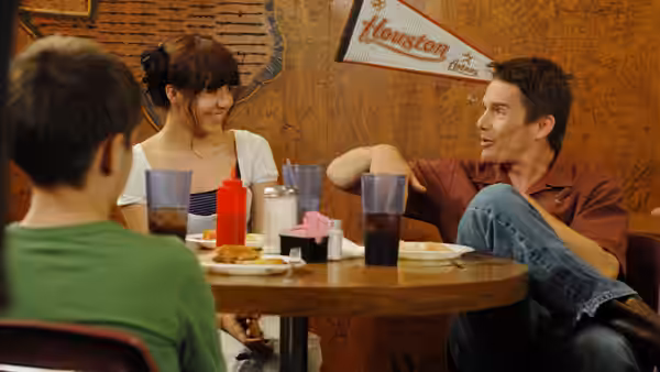 Dad (Ethan Hawke) talks with Mason (Ellar Coltrane) and a woman at a diner table