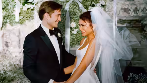 Charlie (Robert Pattinson) and Emma (Zendaya) smiling at each other in wedding attire
