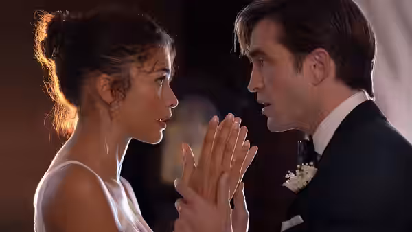 Emma (Zendaya) and Charlie (Robert Pattinson) facing each other with hands raised between them
