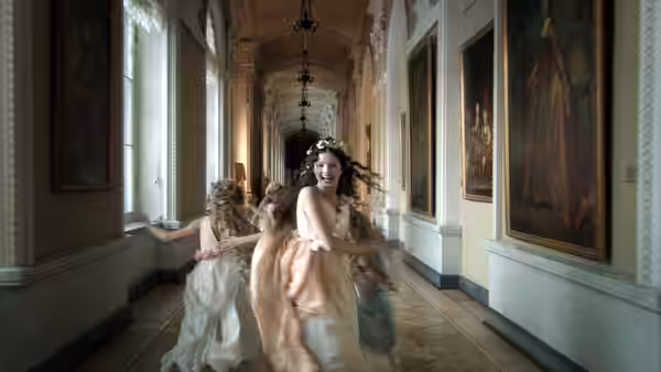 Young dancers in pastel dresses twirl through a gallery lined with paintings
