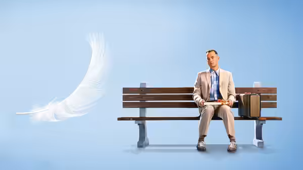 Forrest Gump (Tom Hanks) sitting on a park bench with a floating feather