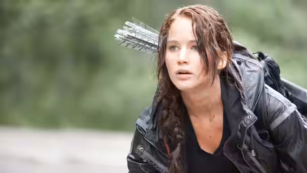 Katniss Everdeen (Jennifer Lawrence) carrying arrows on her back outdoors