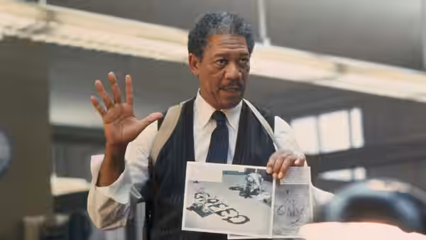 Somerset (Morgan Freeman) gestures while displaying crime scene photographs in an office