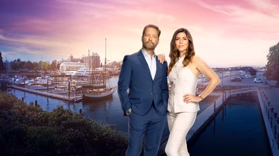 Matt Shade (Jason Priestley) and Angie Everett (Cindy Sampson) pose beside a waterfront marina