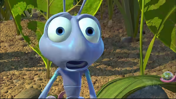 Flik stares wide-eyed among the grass, with a small bug on a leaf