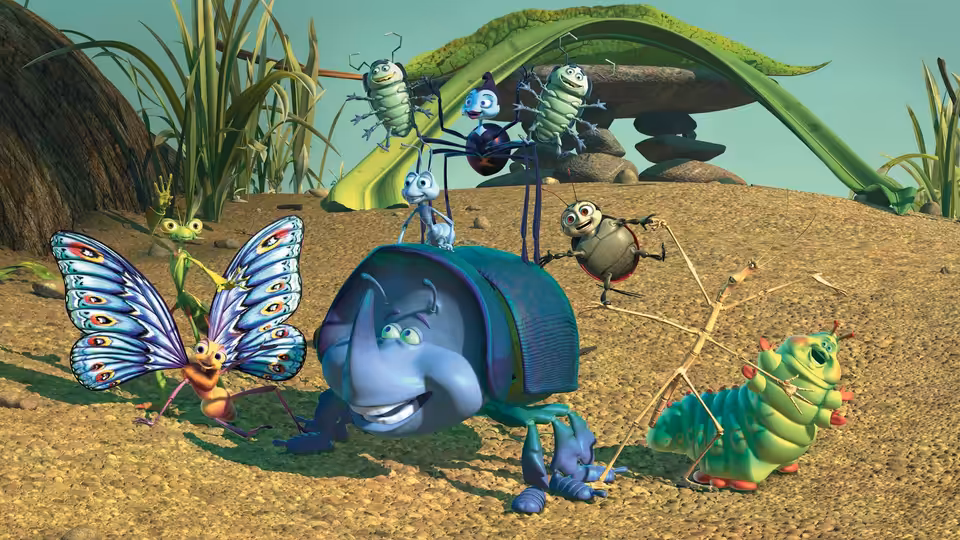 Flik and the circus bugs gather on a dirt mound beneath a leaf shelter