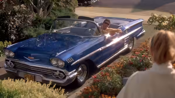 Charlie (Nicolas Cage) leaning out of a blue convertible waving