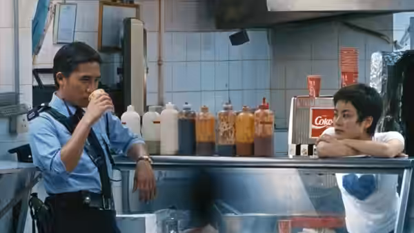 Police officer drinking at a counter while a woman watches him