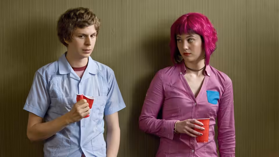 Scott Pilgrim (Michael Cera) and Ramona Flowers (Mary Elizabeth Winstead) holding red cups by a wall