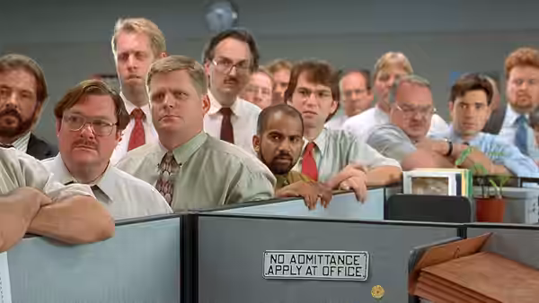 group of office workers leaning over cubicle partitions to look ahead