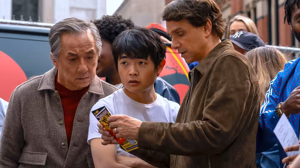 Mr. Han (Jackie Chan) and Li Fong examine a card with another man
