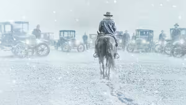 A lone rider approaches a line of automobiles through falling snow