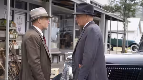 Manny Gault (Woody Harrelson) and Frank Hamer (Kevin Costner) talk beside a parked car