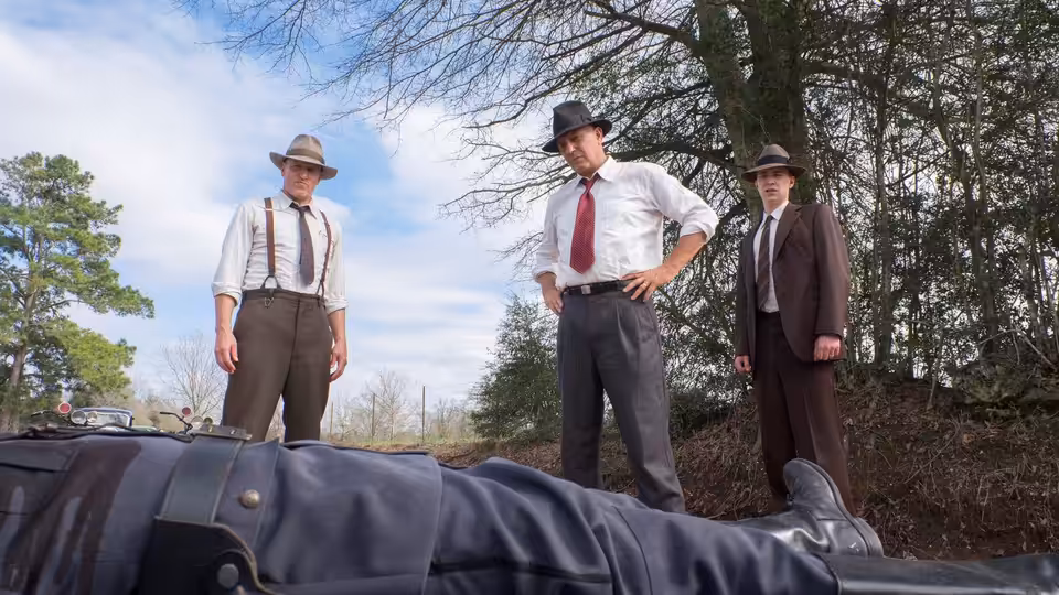 Frank Hamer (Kevin Costner) and two lawmen look down at a body in the road
