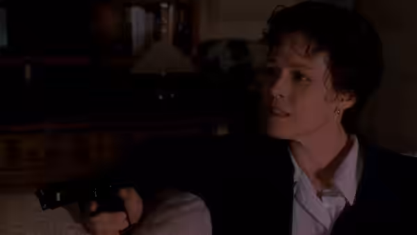 Paulina Escobar (Sigourney Weaver) points a revolver across a dim room