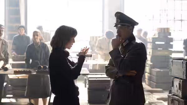 A woman talks with a uniformed officer in a bright industrial workspace
