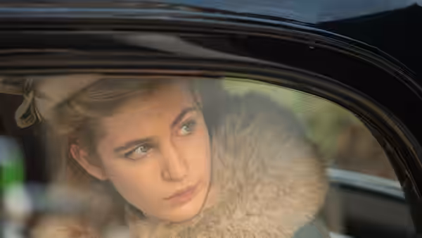 Irena Gut Opdyke (Sophie Nélisse) looks out from a car window, wrapped in a fur collar