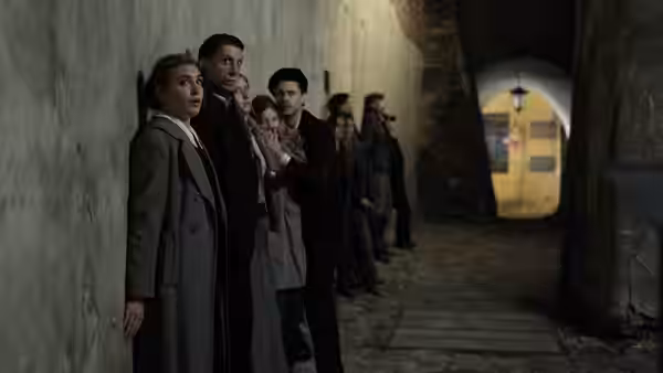 Irena Gut Opdyke (Sophie Nélisse) and others wait along a dim corridor