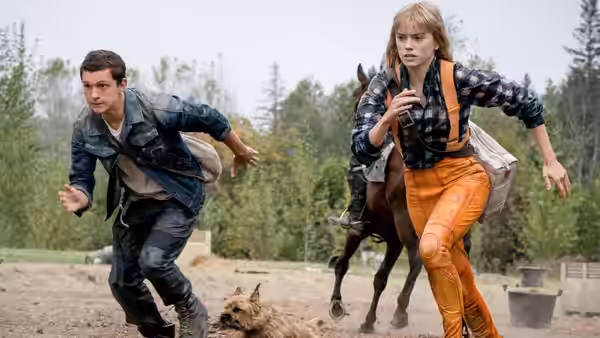 Todd Hewitt (Tom Holland) and Viola Eade (Daisy Ridley) run together across an open settlement