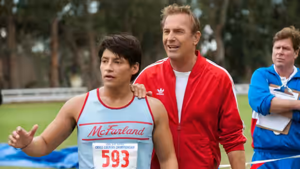 Jim White (Kevin Costner) rests a hand on a runner’s shoulder at the track