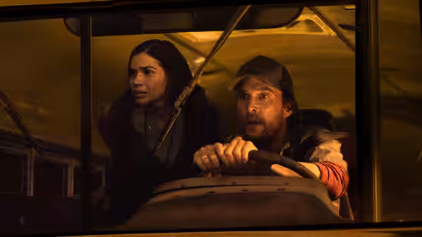 Kevin McKay (Matthew McConaughey) grips the school bus wheel while Mary Ludwig (America Ferrera) looks ahead