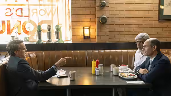 Men meet around a diner table, talking over coffee and food
