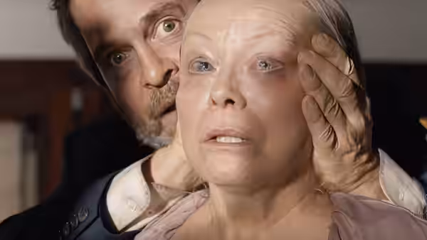 Gary (Tom Hollander) holds Malorie’s face as she stares ahead