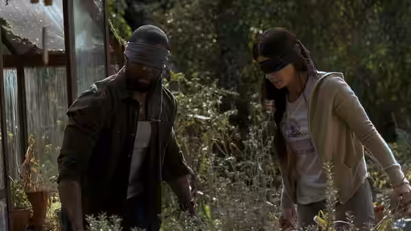 Tom (Trevante Rhodes) and Malorie (Sandra Bullock), blindfolded, tend plants outside