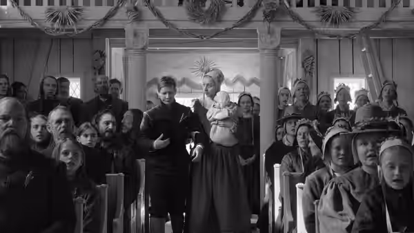 A congregation watches a man holding an infant beside a woman in a church doorway