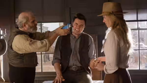 An elderly man points a revolver at Albert as Anna watches