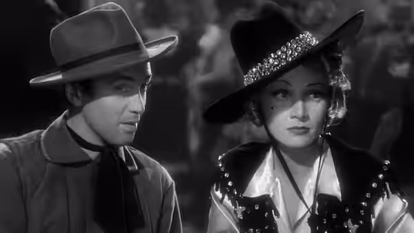 Tom Destry Jr. (James Stewart) and Frenchy (Marlene Dietrich) sit together in cowboy hats