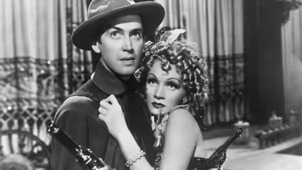 Tom Destry Jr. (James Stewart) embraces Frenchy (Marlene Dietrich) inside a room