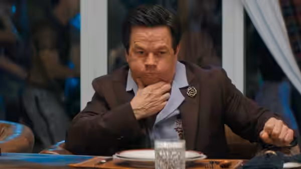 Brad (Mark Wahlberg) sits at a table, resting his hand against his chin