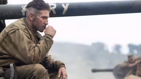 Don Collier (Brad Pitt) sits on a tank, smoking