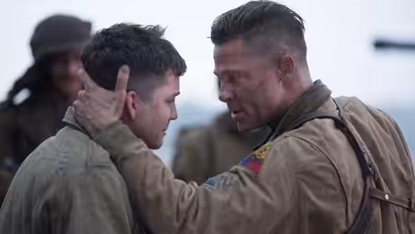 Don Collier (Brad Pitt) holds Norman Ellison (Logan Lerman) by the head