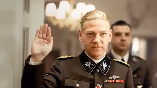 Reinhard Heydrich (Kenneth Branagh) raises his hand before a uniformed official
